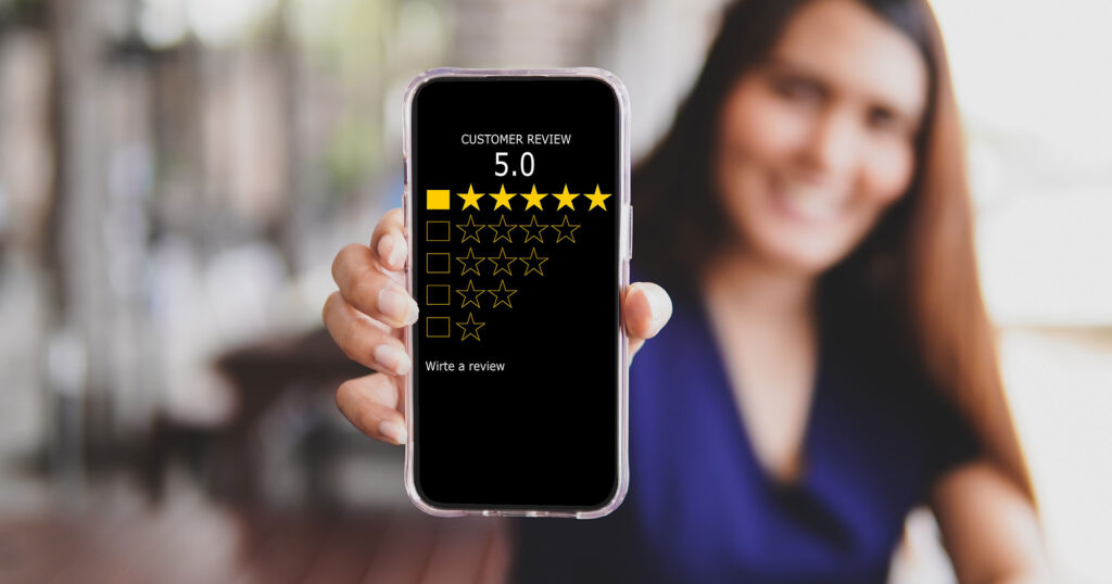 A woman holding up her phone to show great customer reviews.