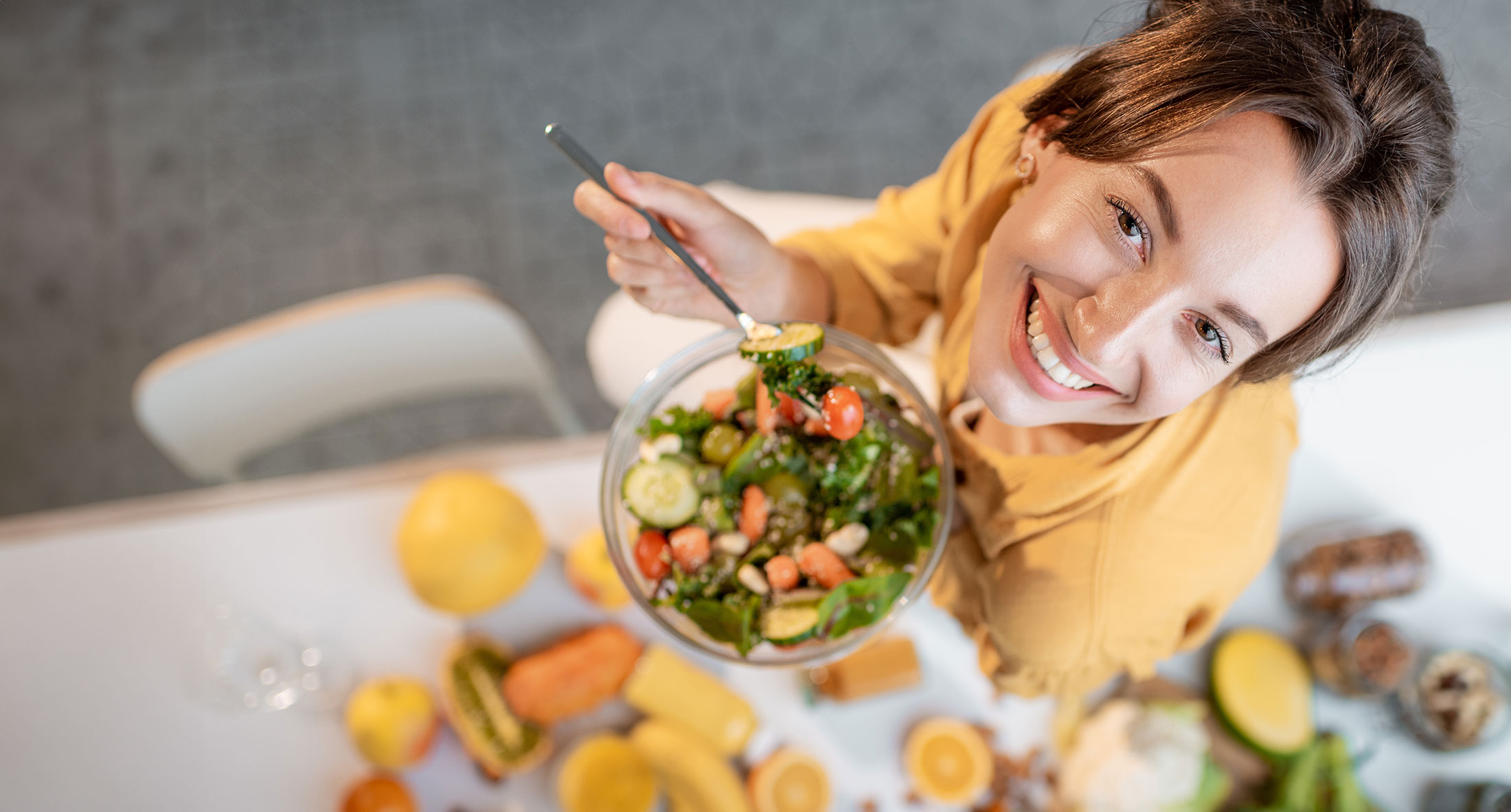 Woman smiling with a bowl of salad.